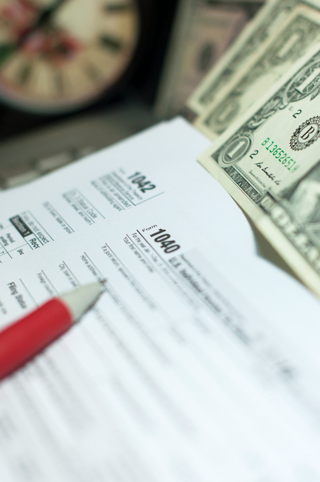 Operational Excellence: The Key to Sustainable Business Growth Tax Season: 1040 U.S. Individual Income Tax Return Form horizontal top view with an office laptop and blue calculator as background together with a red white pen preparation on taxation as foreground